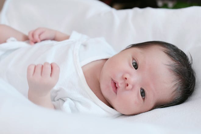 Asian baby in white babygro