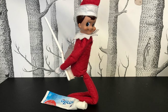 Elf on the shelf playing with tooth brush and tooth paste