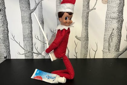 Elf on the Shelf playing with toothbrush and toothpaste