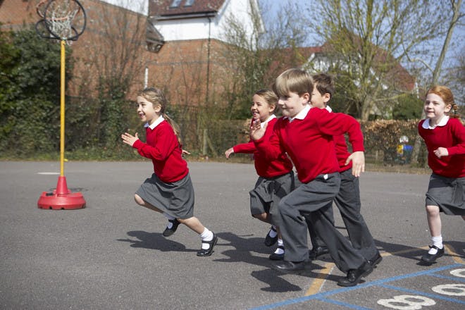 children in school uniform running in school playground