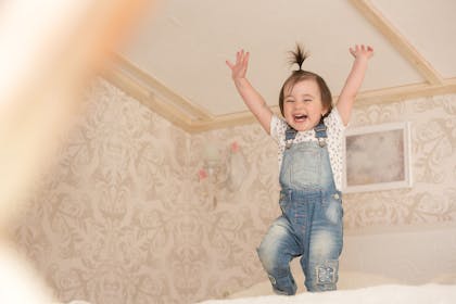 toddler jumping on bed