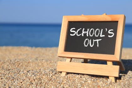 schools out sign on beach