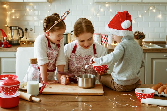 Mother and two children baking in the kitchen on Christmas 