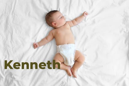 Baby sleeping and lying sprawled out on bed. Name Kenneth written in text