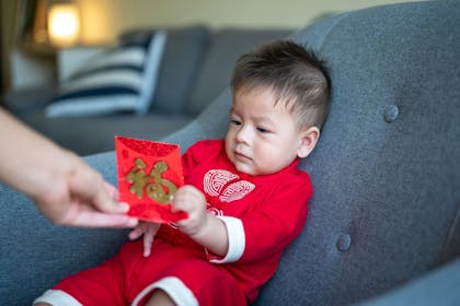 Baby receiving a red money pocket for Chinese New Year