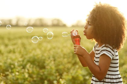 Young girl blowing bubbles