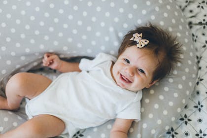 girl with bow in hair lying on her back