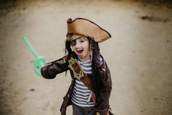 Boy dressed as pirate holding balloon sword
