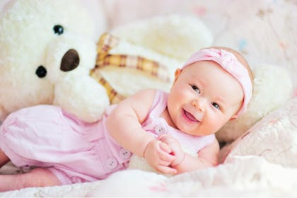 Baby dressed in pink smiling 