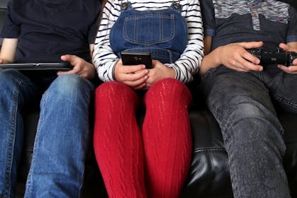 Close up of family holding phones and tablets