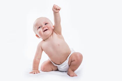 Crawling baby raising fist into the air