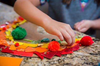 Child making a rainbow collage