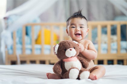 Baby girl holding teddy bear 