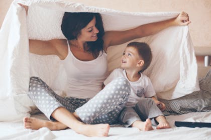 Single mum and child playing on bed