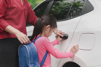 Girl with back pack opening car door