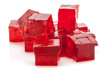 Red jelly cubes on white background
