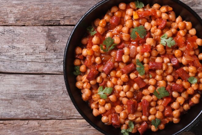 Vegan chickpea stew with tomatoes and peppers in a blackpan