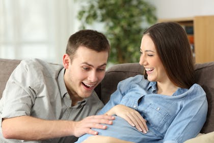 Dad puts hand on mum's pregnancy bump to feel baby kicking