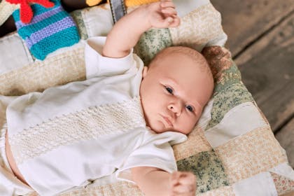 Baby lying on back with arms up