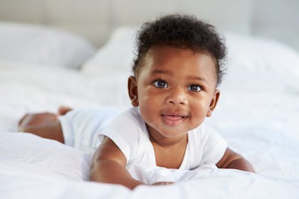 Happy baby lying on front looking up