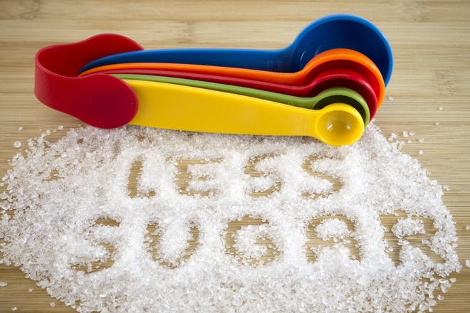 Less sugar written out in sugar with measuring spoons