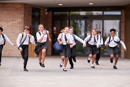 Group of laughing kids running in school playground
