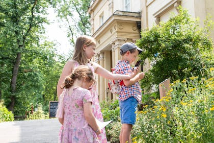 Three children explore the Garden Trail at Elizabeth Gaskell House in Manchester
