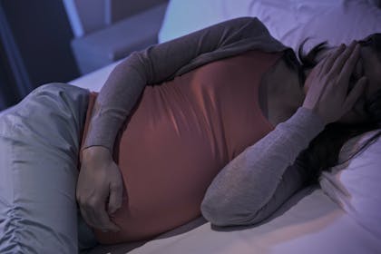 Pregnant woman lying in bed depressed