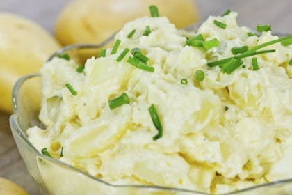 bowl of potato salad with chives on top