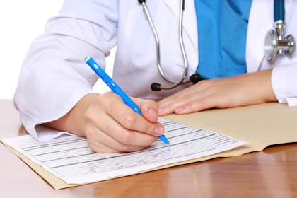 doctor writing notes wearing white coat