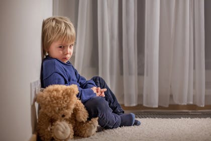 Little boy with a teddy bear looking sad