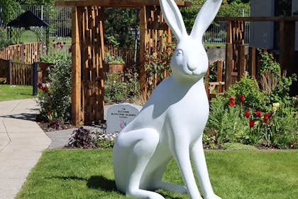 A white hare sculpture in a gorgeous garden, part of The Big Hop Trail 2023