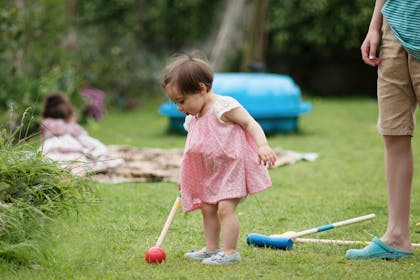 Toddler playing croquet