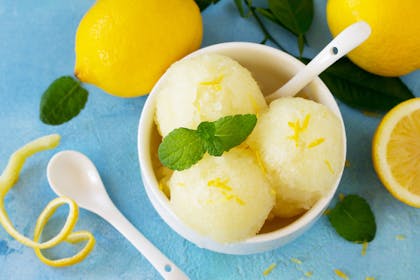 Lemon sorbet in bowl with lemons