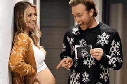 Olly Murs holds baby scan and points at wife's bump