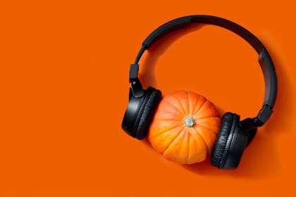 Pumpkin on an orange background with headphones 