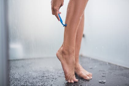 Woman shaving legs in shower