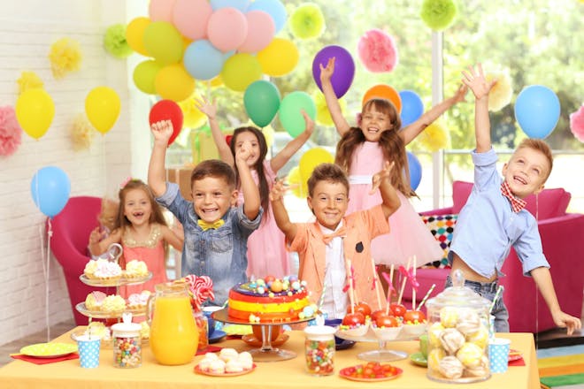 Young boys and girls enjoying a birthday party with cakes and balloons
