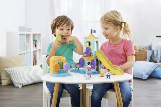 Boy and girl playing with Playmobil dollhouse
