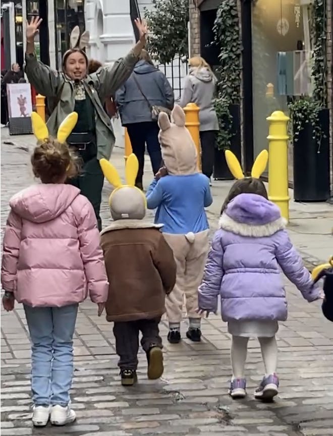 Kids in yellow bunny ears hopping along following Beatrix Potter on her adventure around Covent Garden