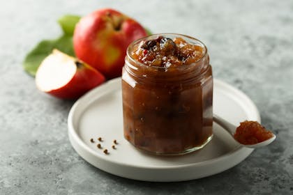 Glass jar of chutney and an apple