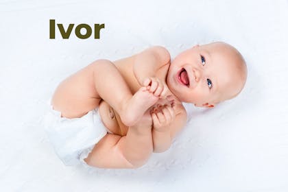 Baby lying on back laughing and holding feet. Name Ivor written in text