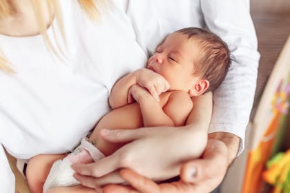 Newborn baby asleep in mother's arms 