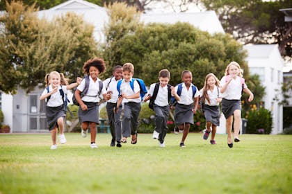 school children running on grass
