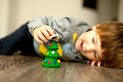 boy playing with plasticine Christmas tree