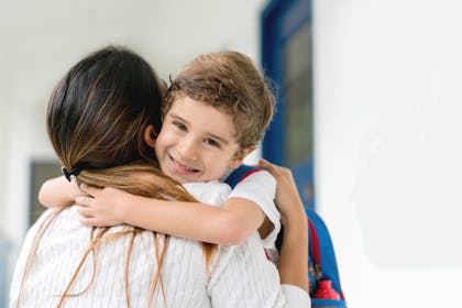 smiling school boy hugging his mum