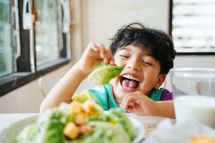 smiling boy eating a salad