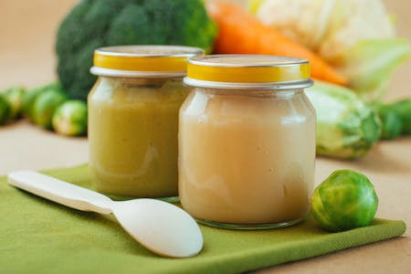 Two jars of Brussels sprouts baby food puree with a spoon