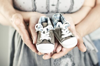 newborn baby boots in parents hands