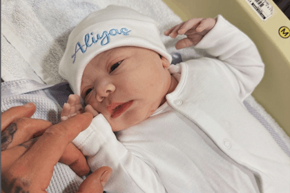 Newborn baby wearing white hat